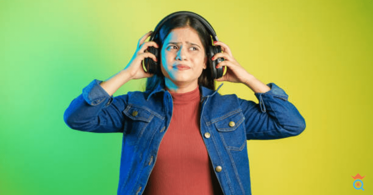 A girl wearing headphones on looking confused