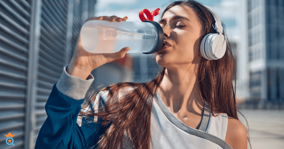 girl wearing headphone in the street while drinking water